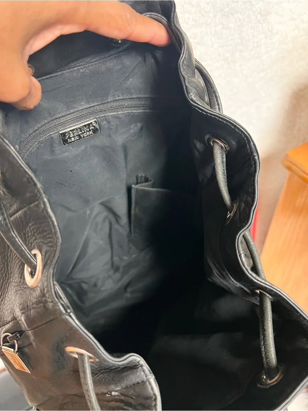 Perlina Black Leather Drawstring Flap Backpack